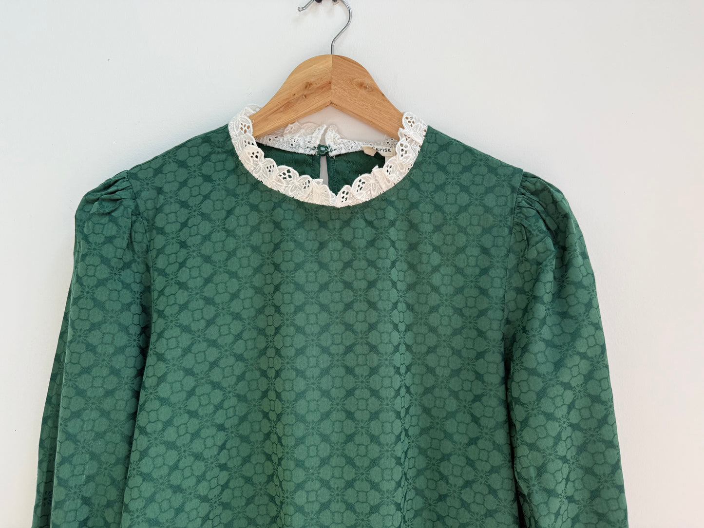 Blouse verte avec motifs et broderie anglaise sur le col et les manches