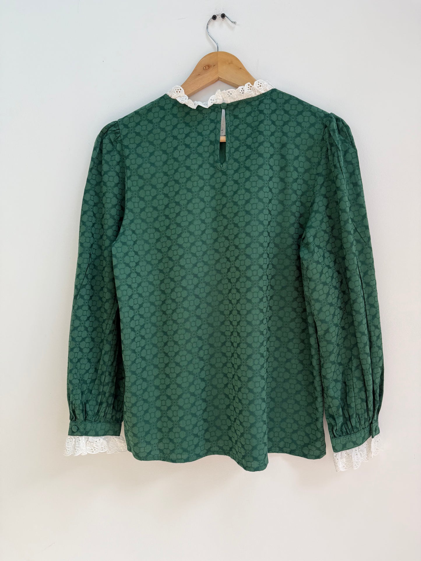 Blouse verte avec motifs et broderie anglaise sur le col et les manches