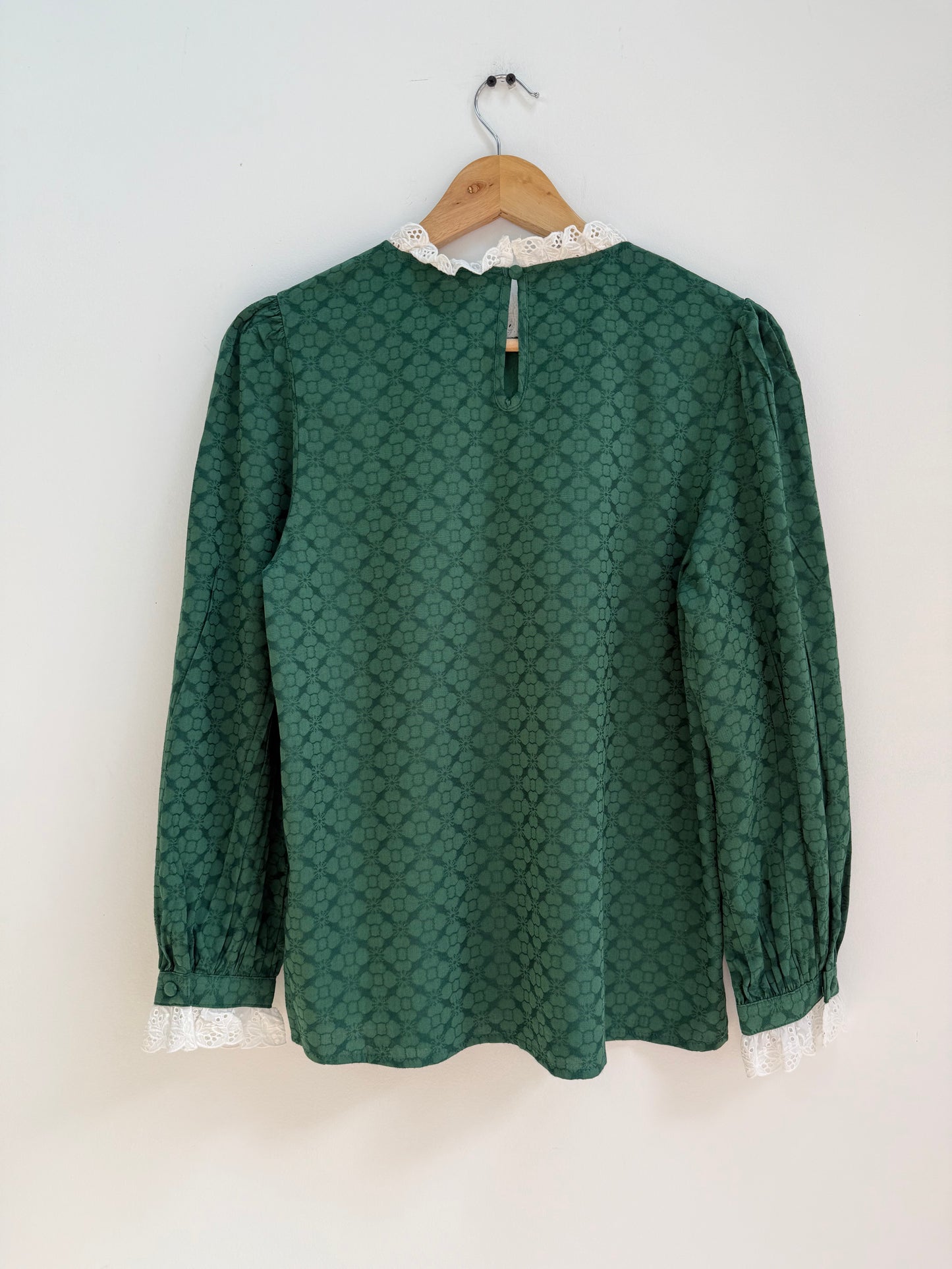 Blouse verte avec motifs et broderie anglaise sur le col et les manches