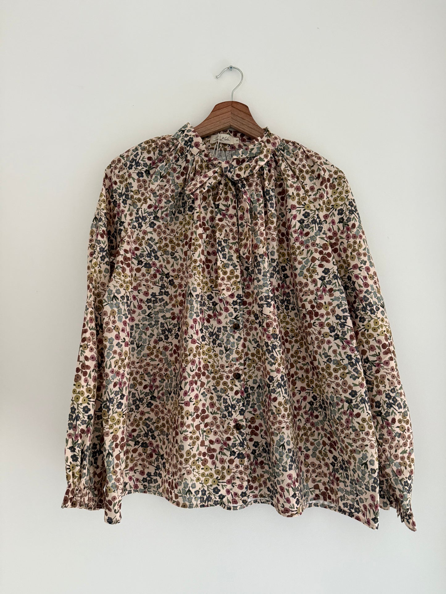 Blouse col lavallière beige avec motifs fleuris