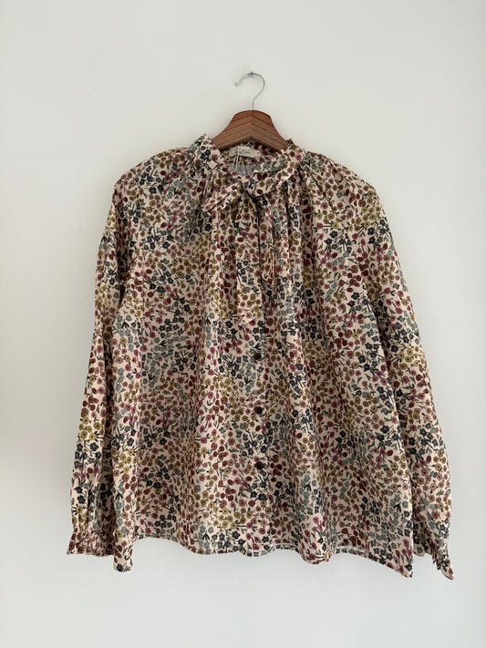 Blouse col lavallière beige avec motifs fleuris