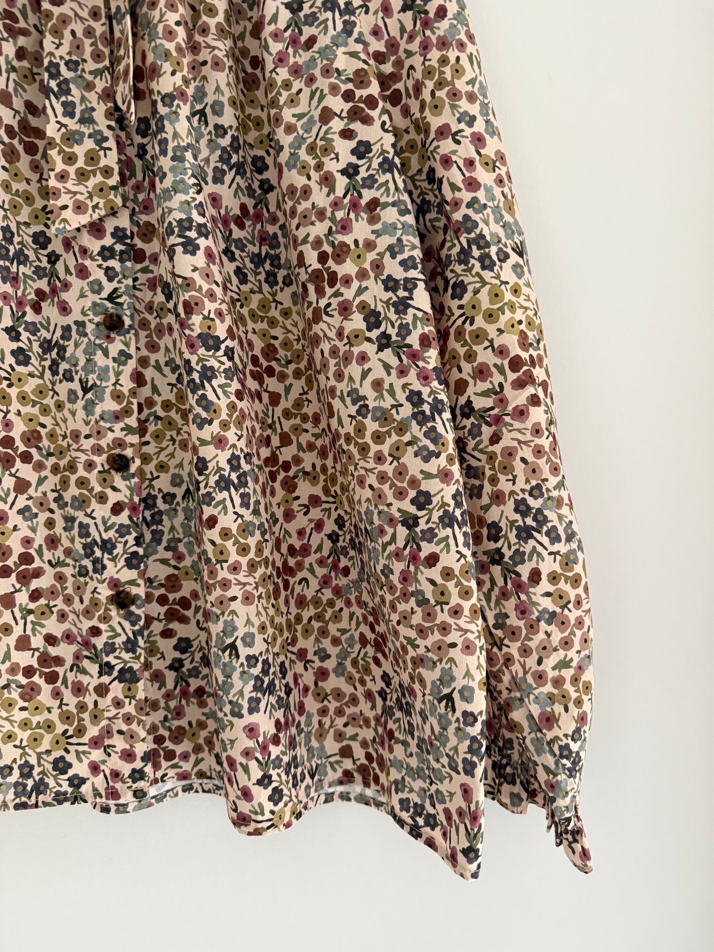 Blouse col lavallière beige avec motifs fleuris