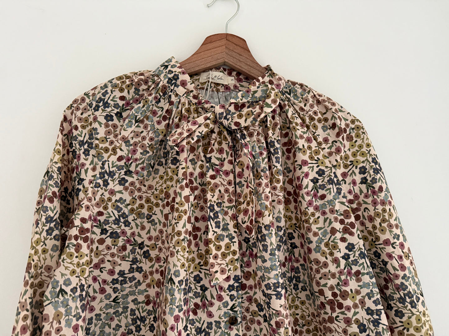 Blouse col lavallière beige avec motifs fleuris