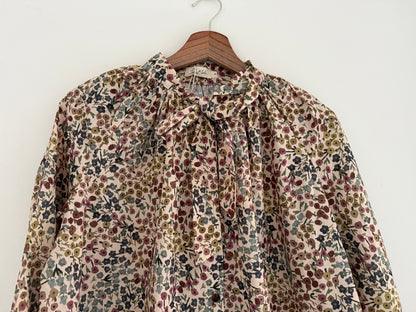 Blouse col lavallière beige avec motifs fleuris