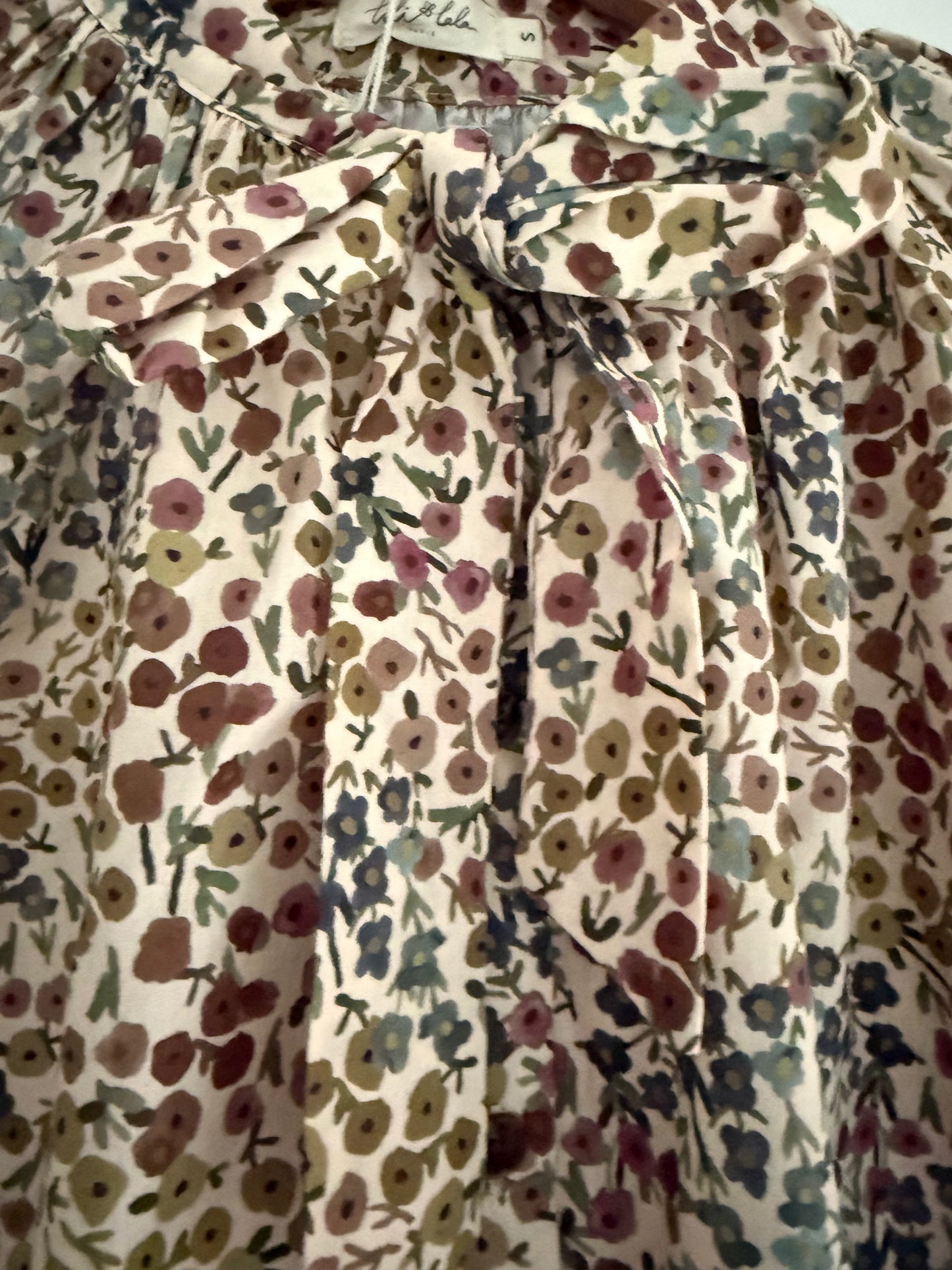 Blouse col lavallière beige avec motifs fleuris