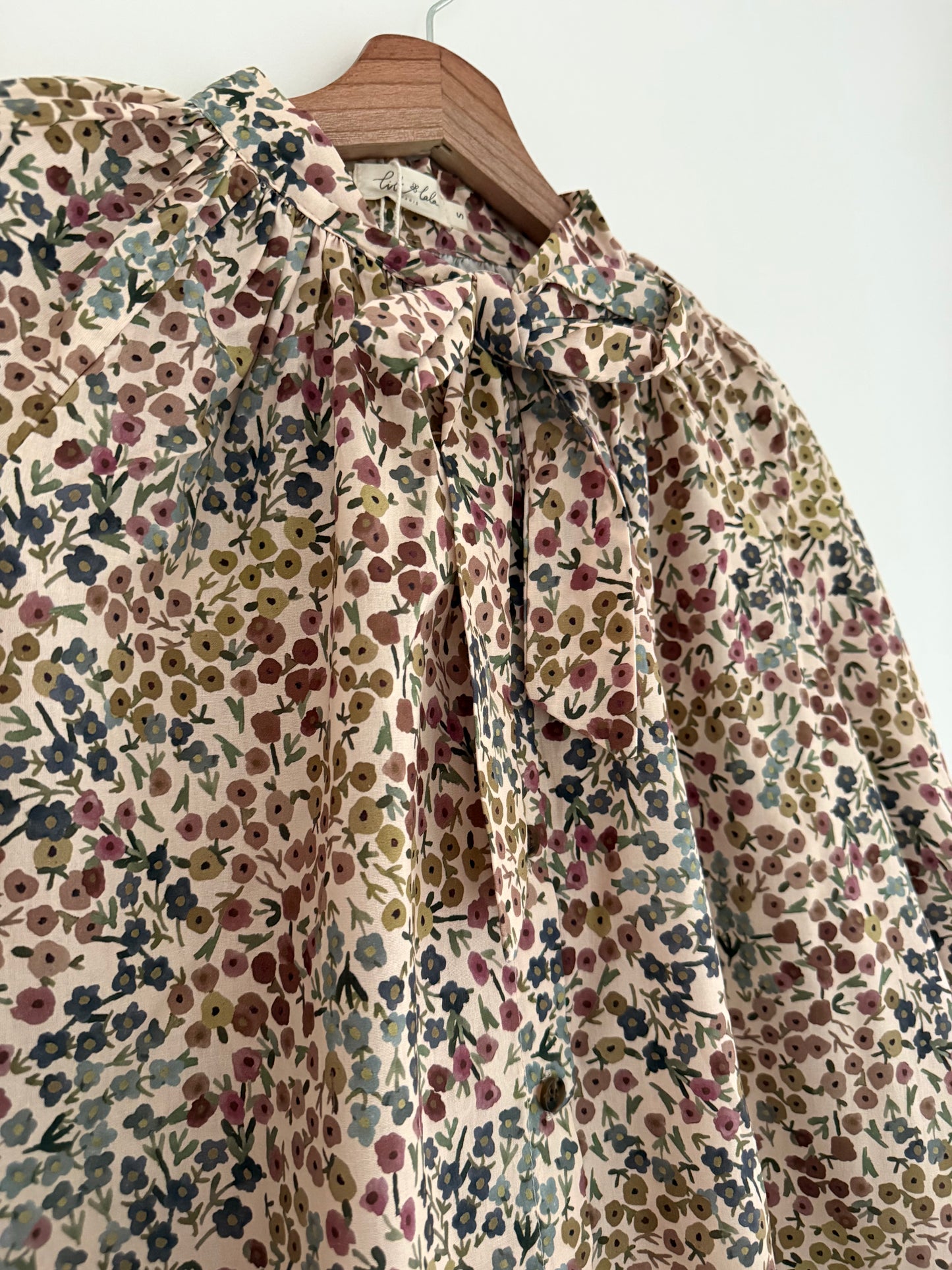 Blouse col lavallière beige avec motifs fleuris