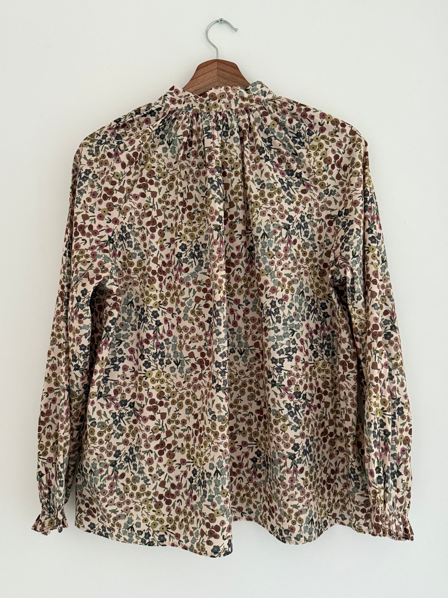 Blouse col lavallière beige avec motifs fleuris