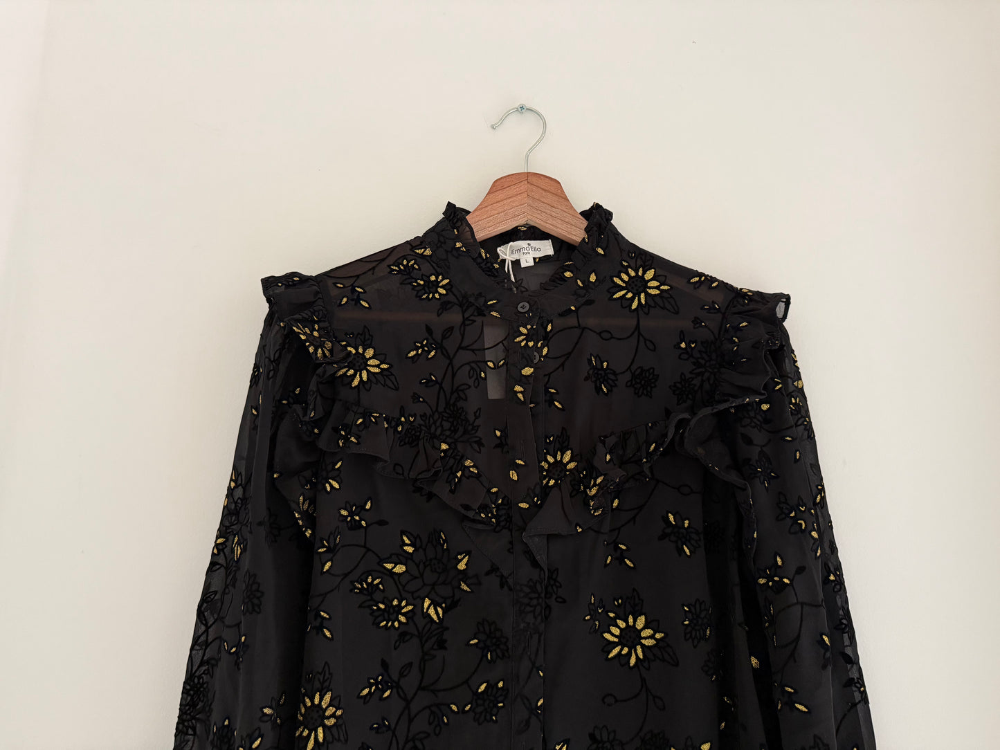 Blouse froufrous noire avec motifs en relief et détails dorés