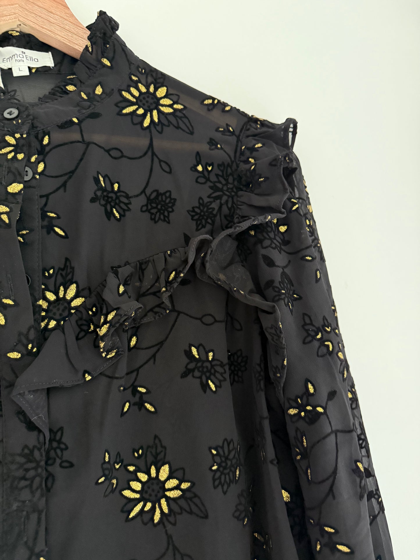 Blouse froufrous noire avec motifs en relief et détails dorés