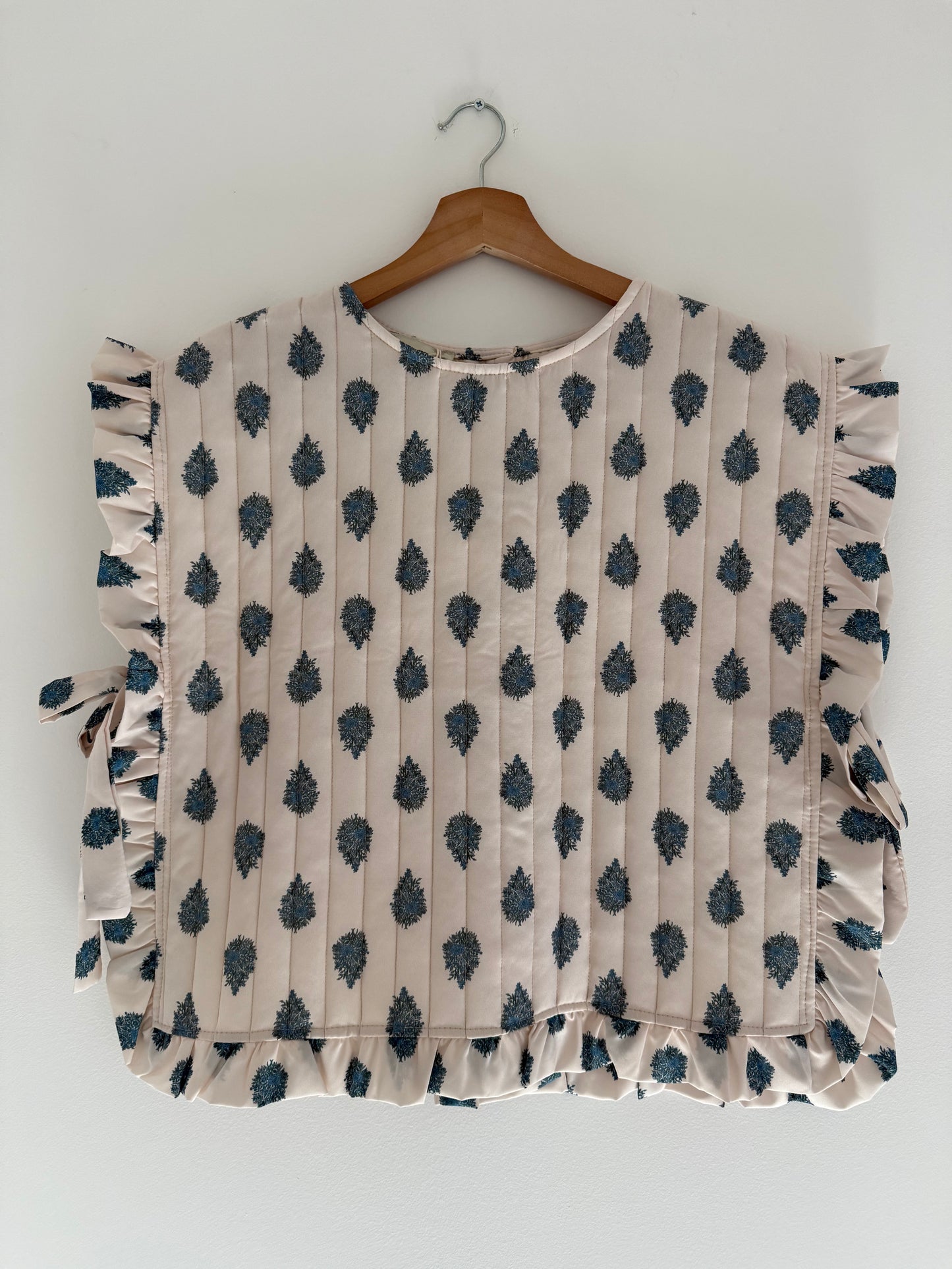 Plastron matelassé crème avec motifs bleus et boutons dans le dos&nbsp;