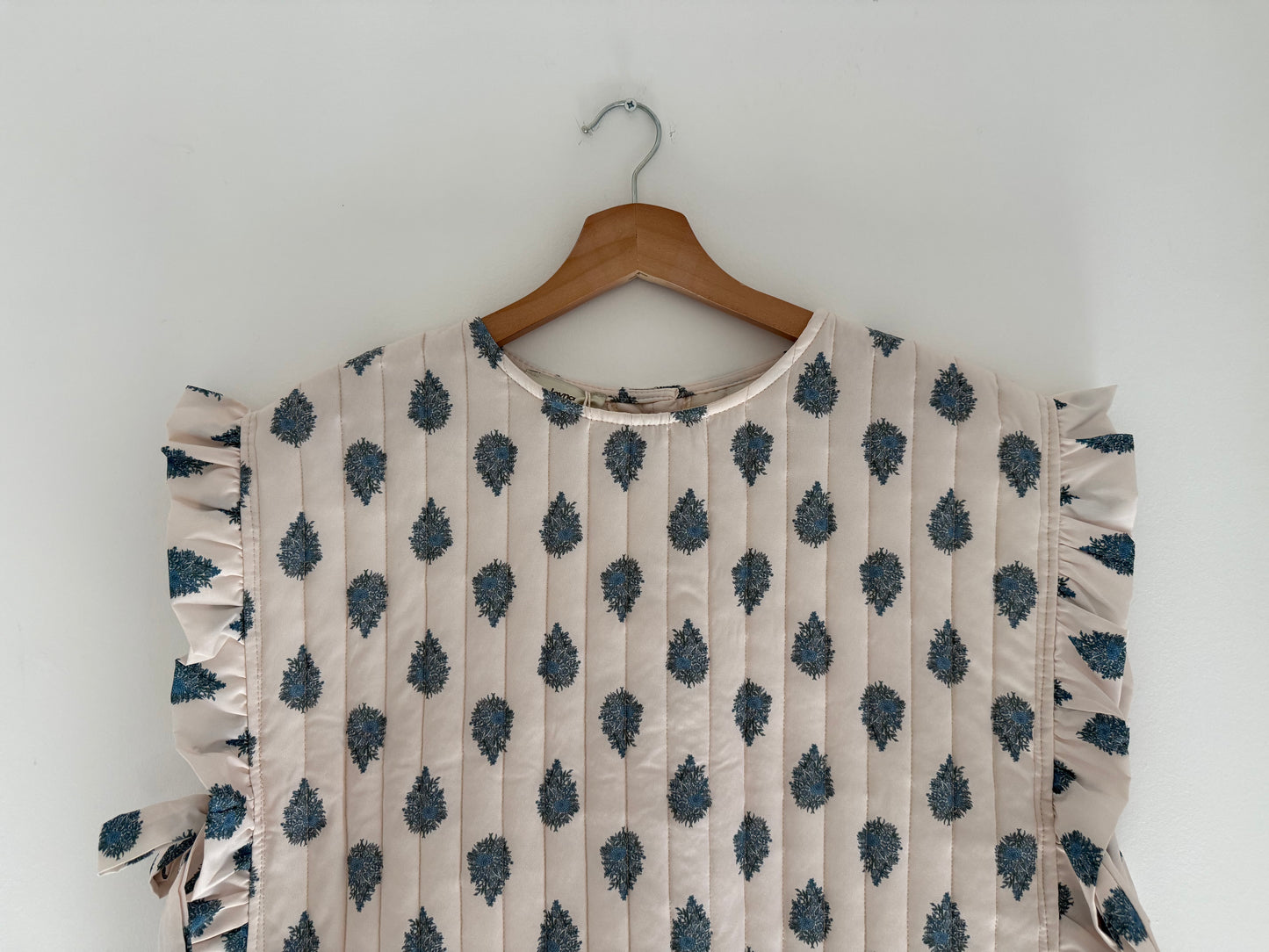 Plastron matelassé crème avec motifs bleus et boutons dans le dos&nbsp;