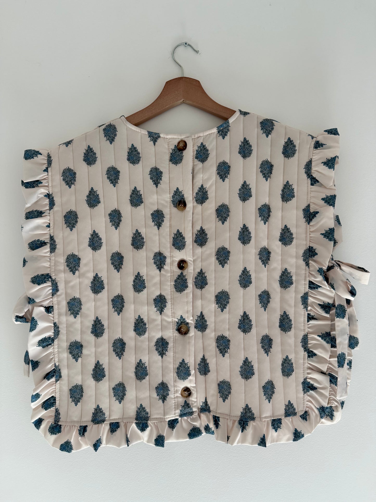 Plastron matelassé crème avec motifs bleus et boutons dans le dos&nbsp;