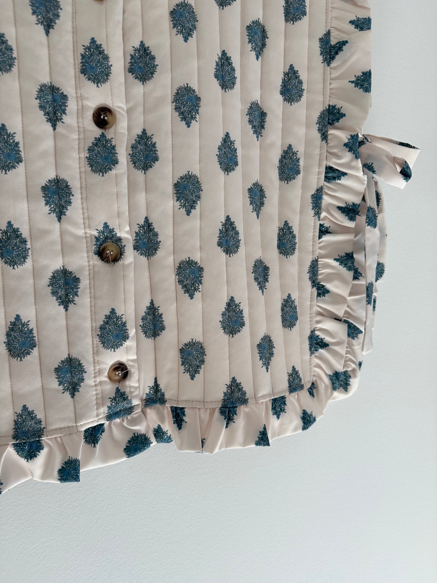 Plastron matelassé crème avec motifs bleus et boutons dans le dos&nbsp;