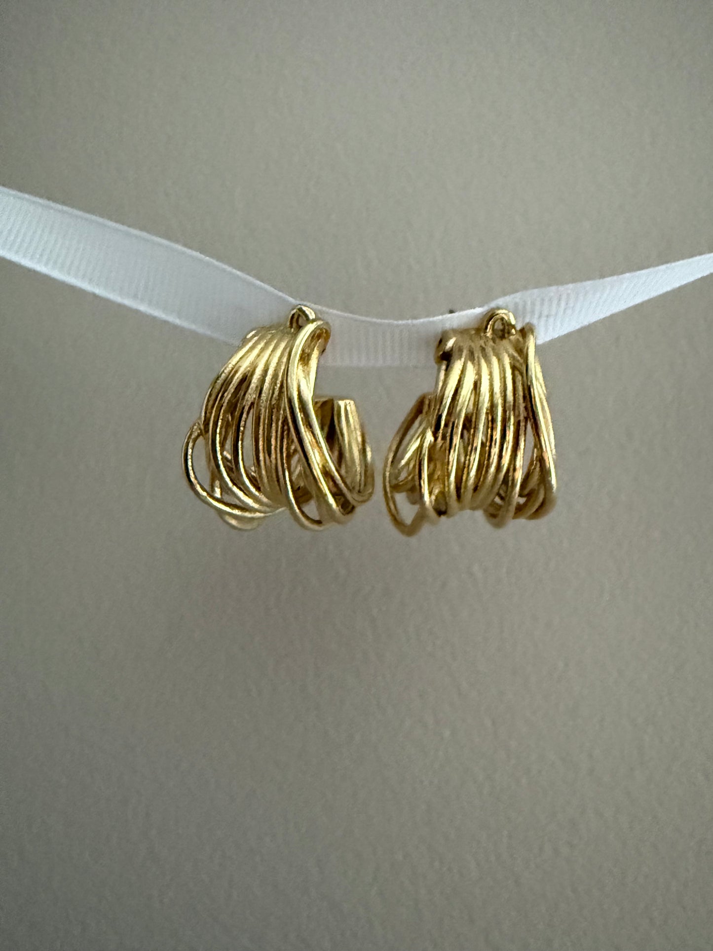 Boucles d'oreilles avec entrelacement de fines courbes métalliques dorées